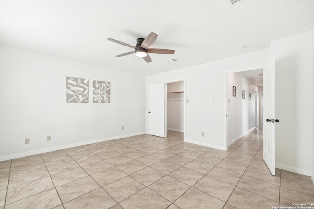 empty room with ceiling fan and light tile patterned floors