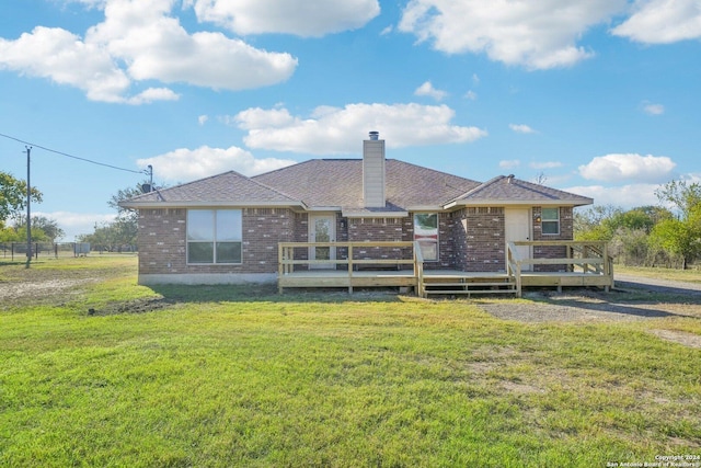 rear view of house featuring a yard and a deck