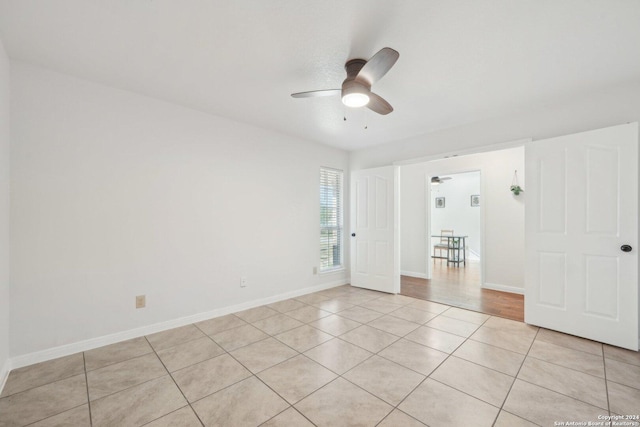 unfurnished room with light tile patterned floors and ceiling fan