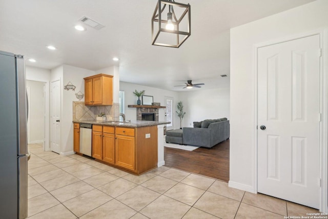 kitchen with pendant lighting, sink, ceiling fan, kitchen peninsula, and stainless steel appliances