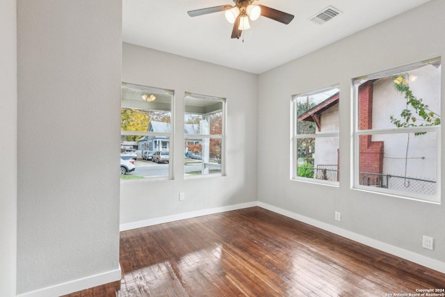 empty room with dark hardwood / wood-style floors and ceiling fan