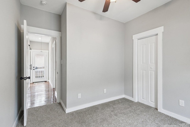 unfurnished bedroom featuring carpet floors, a closet, and ceiling fan