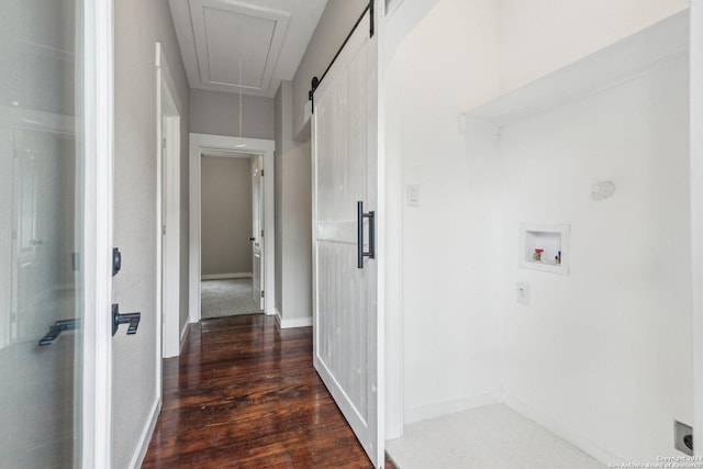 hall with a barn door and dark wood-type flooring