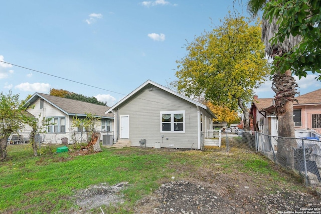 back of property featuring a yard and central air condition unit