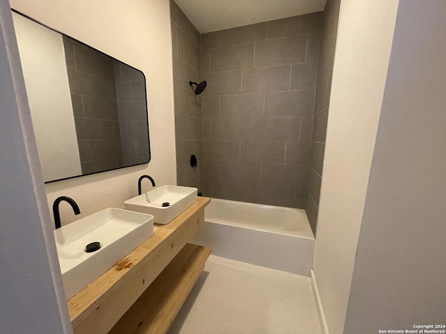 bathroom featuring tiled shower / bath combo and sink