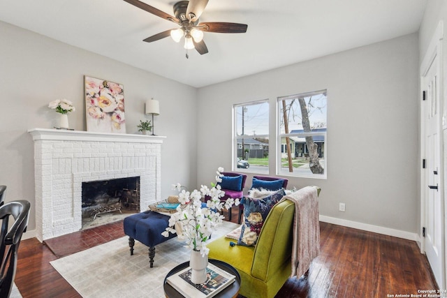 living room with a fireplace, dark hardwood / wood-style flooring, and ceiling fan