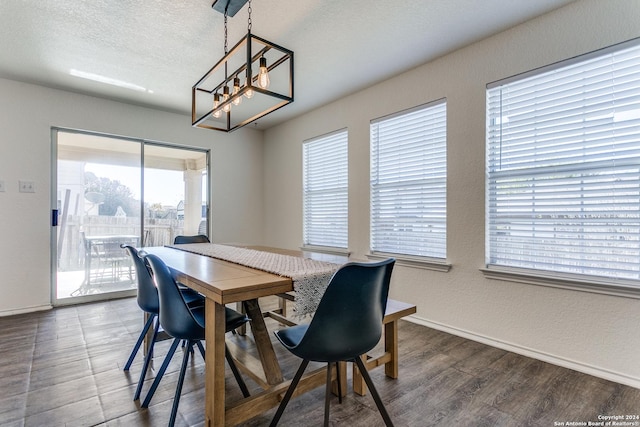 dining room featuring a textured ceiling, hardwood / wood-style flooring, and a notable chandelier