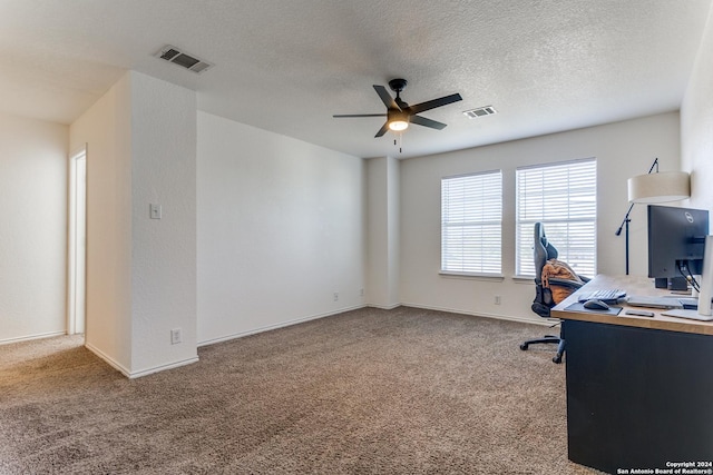 carpeted office space featuring ceiling fan and a textured ceiling