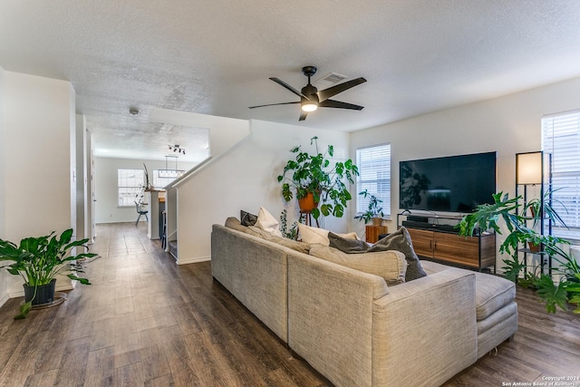 living room featuring a textured ceiling, a wealth of natural light, ceiling fan, and dark hardwood / wood-style floors