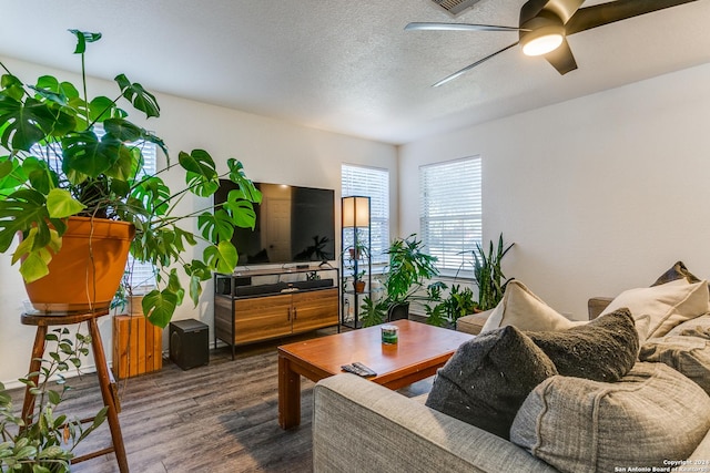 living room featuring a textured ceiling, dark hardwood / wood-style flooring, and ceiling fan