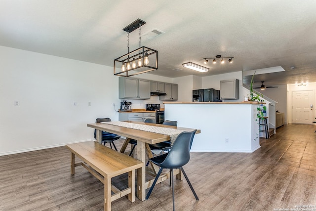 dining room with hardwood / wood-style floors, a textured ceiling, and ceiling fan