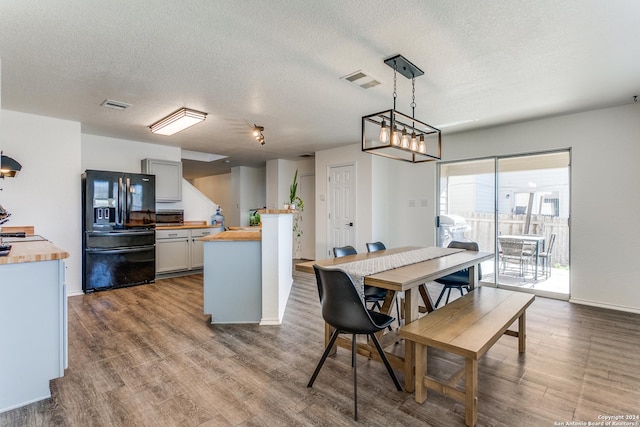 dining area with a textured ceiling and hardwood / wood-style flooring