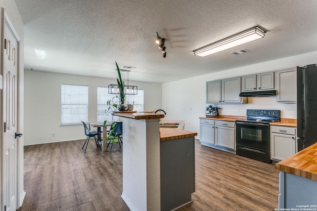 kitchen featuring black appliances, dark hardwood / wood-style floors, butcher block counters, and hanging light fixtures