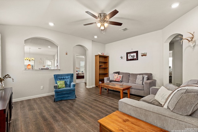 living room featuring ceiling fan with notable chandelier, dark hardwood / wood-style floors, and vaulted ceiling