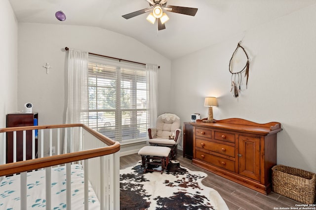 bedroom with hardwood / wood-style flooring, vaulted ceiling, a nursery area, and ceiling fan