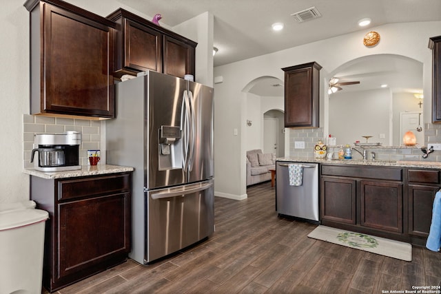 kitchen with backsplash, stainless steel appliances, vaulted ceiling, ceiling fan, and dark wood-type flooring