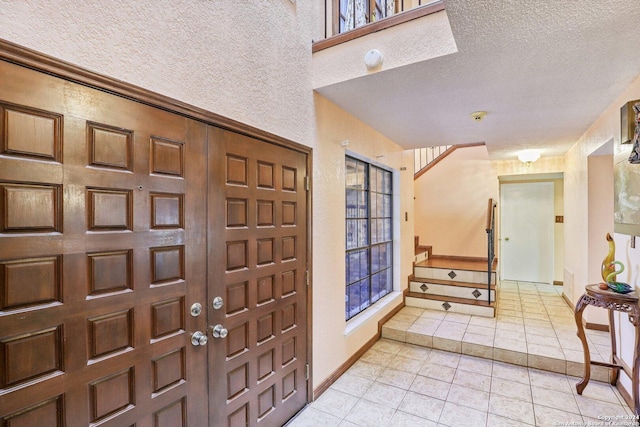 entryway featuring a textured ceiling and light tile patterned flooring