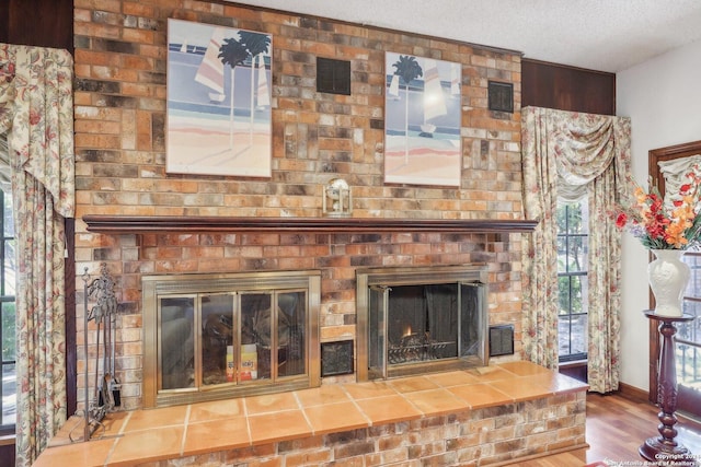 details featuring a fireplace, a textured ceiling, and hardwood / wood-style flooring