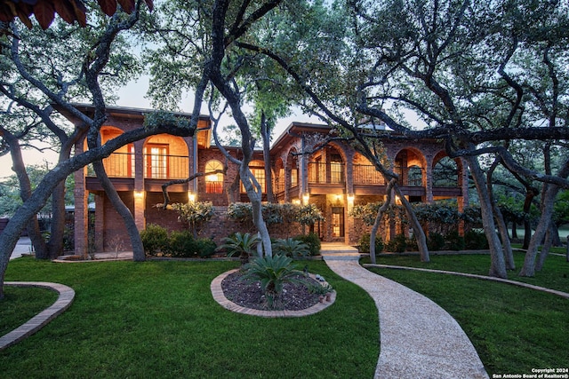 view of front facade with a balcony and a yard