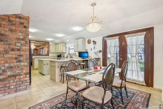 dining room with french doors, a textured ceiling, light tile patterned floors, and vaulted ceiling