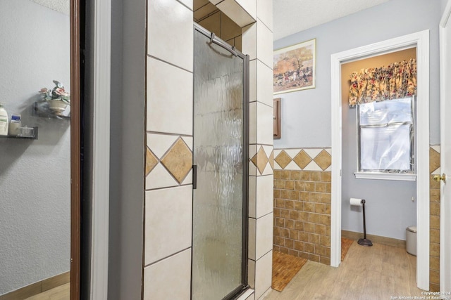 bathroom with hardwood / wood-style floors, a textured ceiling, toilet, and walk in shower