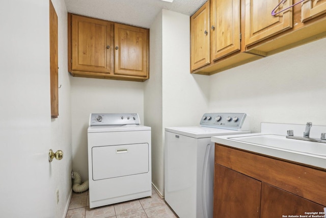 washroom with cabinets, a textured ceiling, sink, light tile patterned floors, and independent washer and dryer