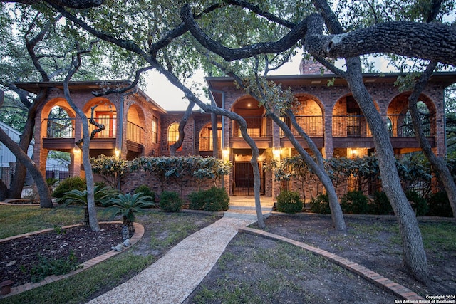 view of front facade featuring a balcony and a front lawn