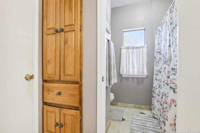 bathroom with tile patterned floors, a shower with curtain, and toilet