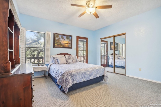 carpeted bedroom with multiple windows, ceiling fan, a closet, and a textured ceiling