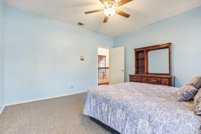 bedroom with ceiling fan, carpet, and a textured ceiling