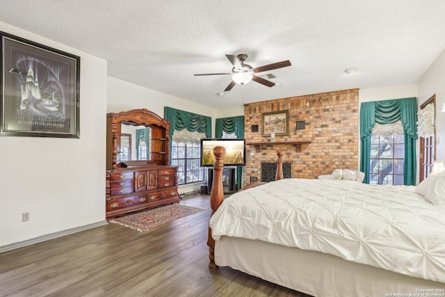 bedroom with ceiling fan, dark wood-type flooring, and a textured ceiling