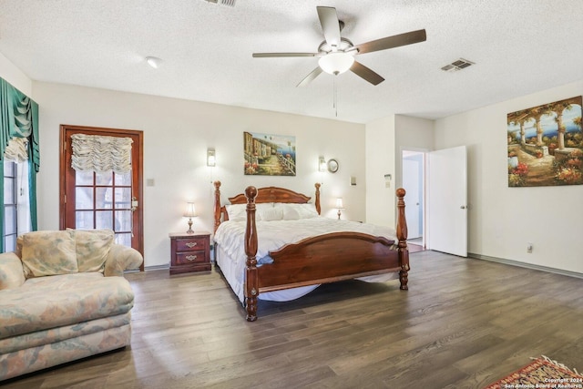 bedroom with a textured ceiling, dark hardwood / wood-style flooring, and ceiling fan