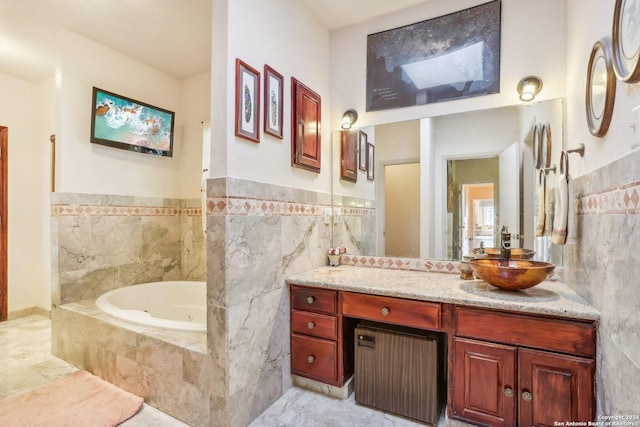 bathroom with tile patterned floors, vanity, tile walls, and tiled tub