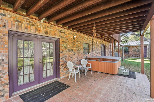 view of patio / terrace featuring a hot tub and french doors