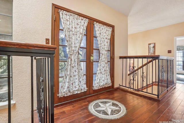 entryway featuring a healthy amount of sunlight, french doors, dark wood-type flooring, and a textured ceiling