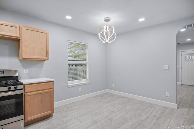 kitchen featuring stainless steel range, light hardwood / wood-style floors, hanging light fixtures, and a notable chandelier