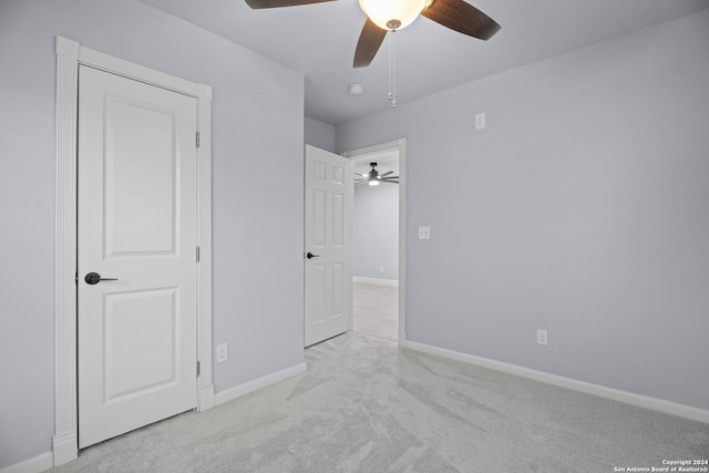 unfurnished bedroom with ceiling fan and light carpet