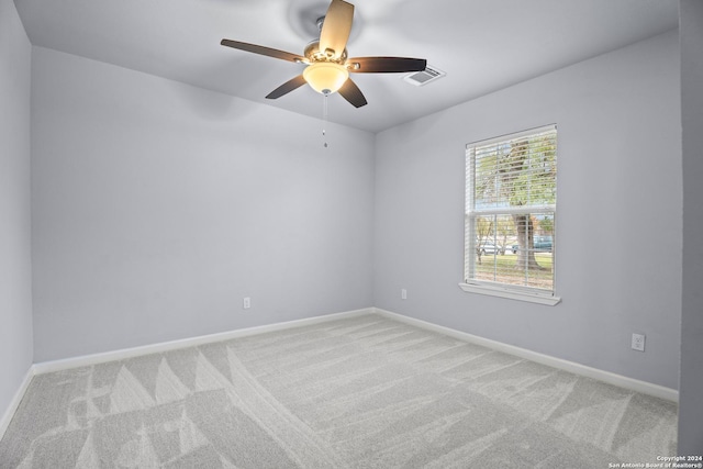 spare room with ceiling fan and light colored carpet