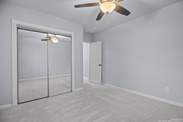 unfurnished bedroom with light colored carpet, a closet, and ceiling fan