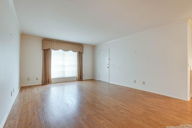 spare room with crown molding and light hardwood / wood-style flooring