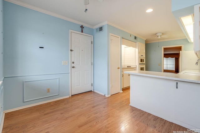 kitchen with white cabinetry, light hardwood / wood-style flooring, ceiling fan, and ornamental molding