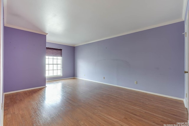 spare room with hardwood / wood-style floors and crown molding