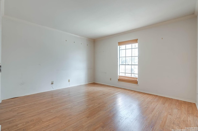 empty room with light wood-type flooring and ornamental molding