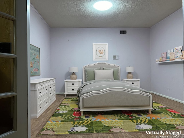 bedroom with wood-type flooring and a textured ceiling