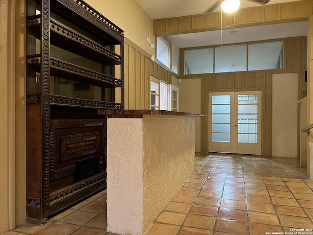 kitchen with french doors, a textured ceiling, high vaulted ceiling, and ceiling fan