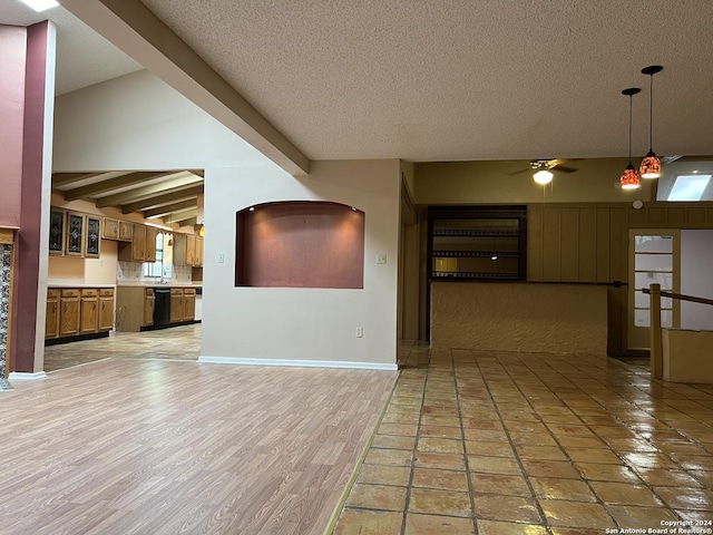 interior space with a textured ceiling, vaulted ceiling with beams, light hardwood / wood-style floors, and ceiling fan