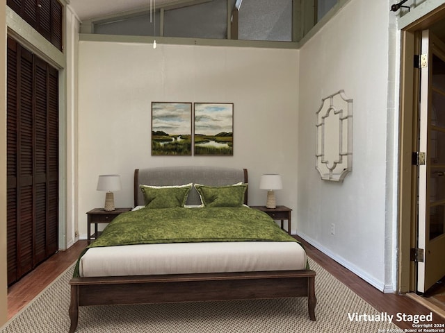 bedroom featuring a closet, wood-type flooring, and vaulted ceiling