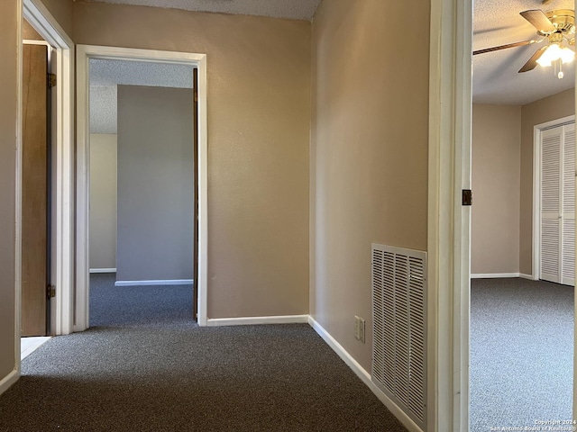 corridor featuring carpet flooring and a textured ceiling