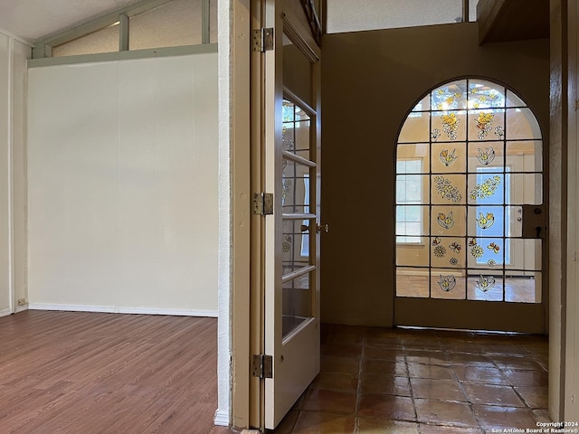 foyer entrance with vaulted ceiling, a textured ceiling, and dark hardwood / wood-style floors