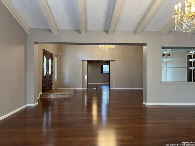 interior space with a healthy amount of sunlight, dark hardwood / wood-style flooring, a textured ceiling, and an inviting chandelier